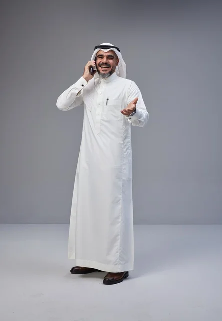 رجل سعودي بالزي التقليدي يتحدث عبر الهاتف الجوال