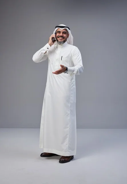 رجل سعودي بالزي التقليدي يتحدث عبر الهاتف المحمول