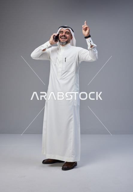 رجل سعودي بالزي التقليدي يتحدث عبر الهاتف