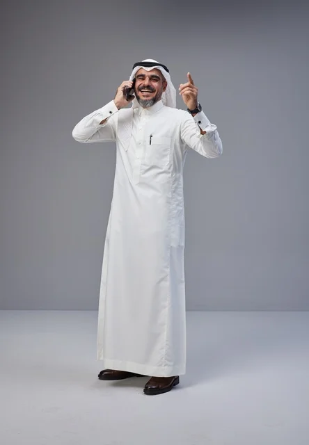 Saudi Man in Traditional Dress Talking on Phone