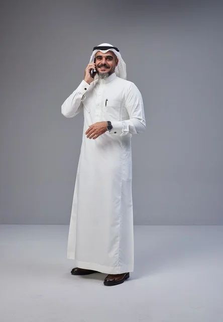 رجل سعودي بالزي التقليدي يتحدث عبر الهاتف المحمول
