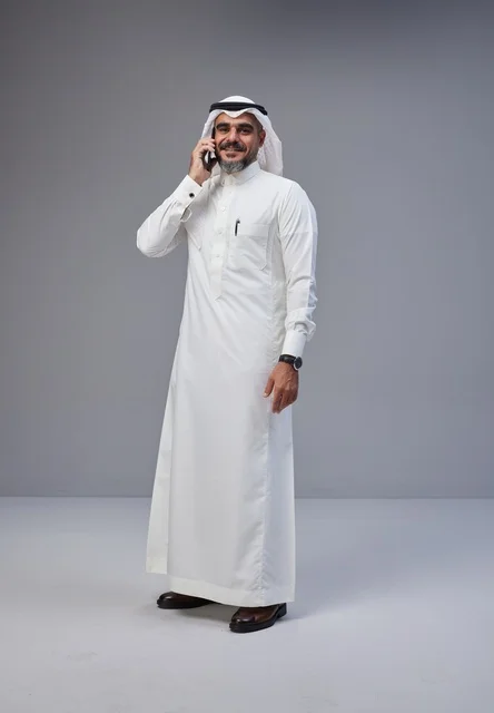 Saudi Man in Traditional Thobe Talking on Smartphone