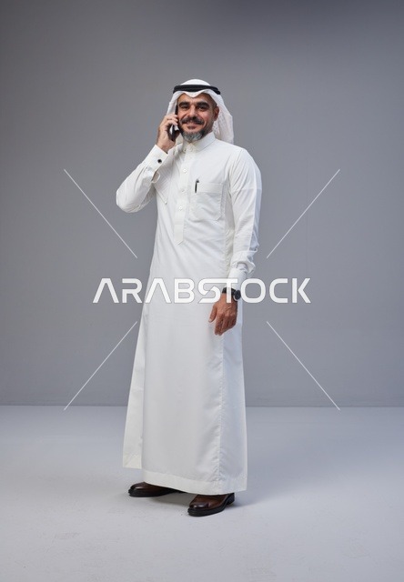 رجل سعودي بالزي التقليدي يتحدث بالجوال في الاستوديو