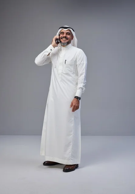 رجل سعودي بالزي التقليدي يتحدث عبر الهاتف المحمول