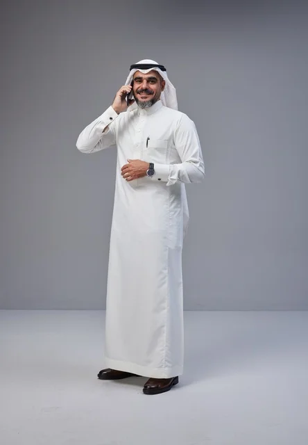 رجل سعودي بالزي التقليدي يتحدث عبر الهاتف الجوال