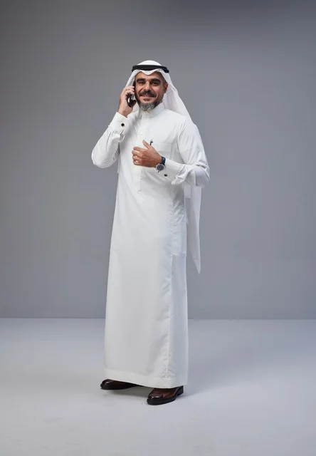Saudi Man in Traditional Dress Talking on Smartphone
