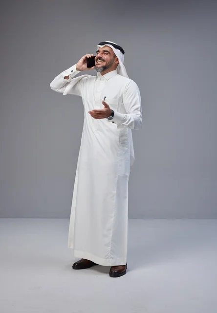 رجل سعودي بالزي التقليدي يتحدث عبر الهاتف المحمول