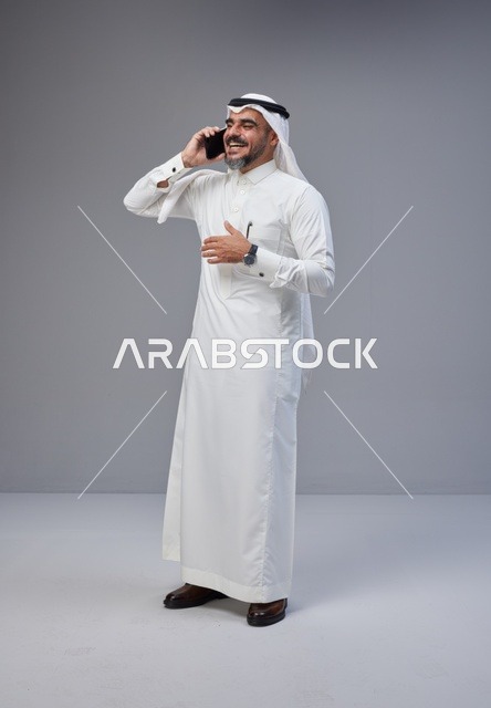 رجل سعودي بالزي التقليدي يتحدث عبر الجوال