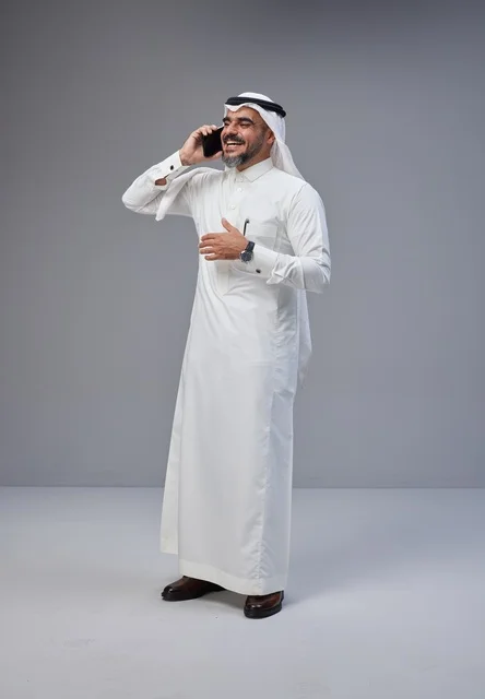 Saudi Man in Traditional Thobe Talking on Phone