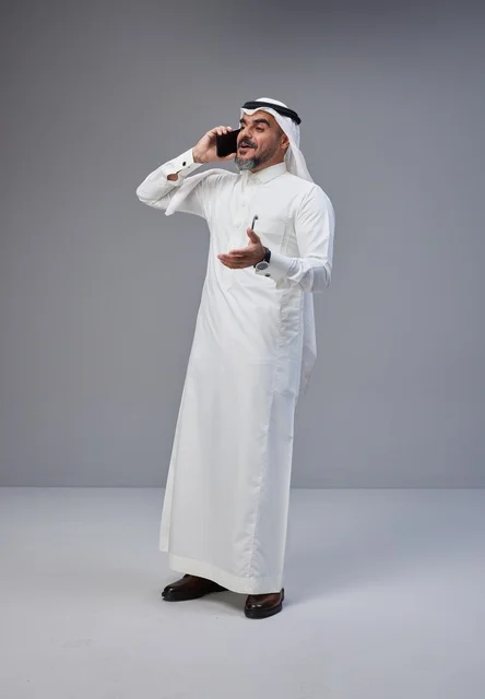 Saudi Man in Traditional Dress Using Smartphone