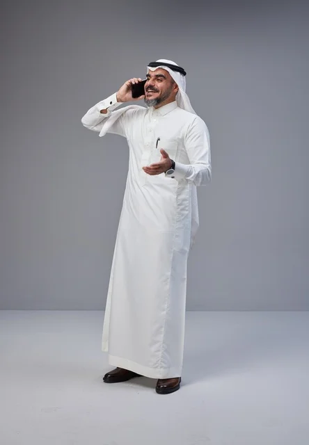 رجل سعودي بالزي التقليدي يتحدث عبر الهاتف الجوال