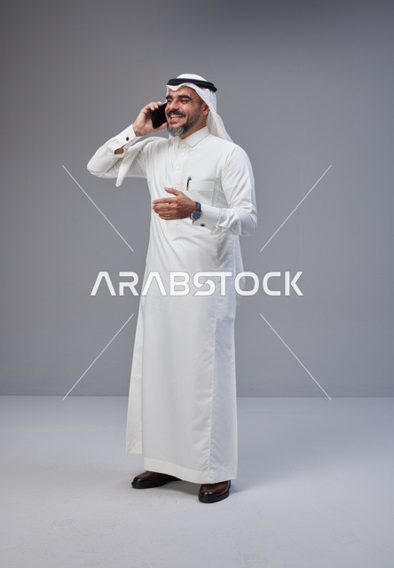 رجل سعودي بالزي التقليدي يتحدث عبر الجوال