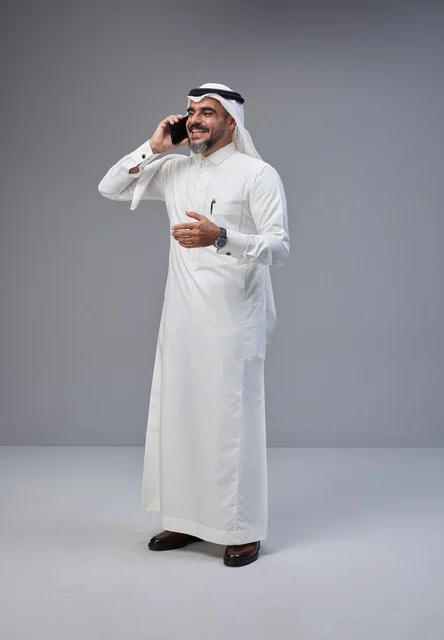 Saudi Man in Traditional Thobe Talking on Phone