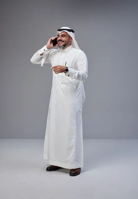 رجل سعودي بالزي التقليدي يتحدث عبر الهاتف الجوال