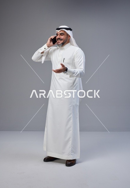 Saudi Man in Traditional Thobe Talking on Mobile Phone