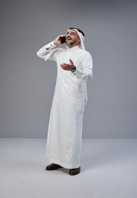 Saudi Man in Traditional Dress Talking on Smartphone