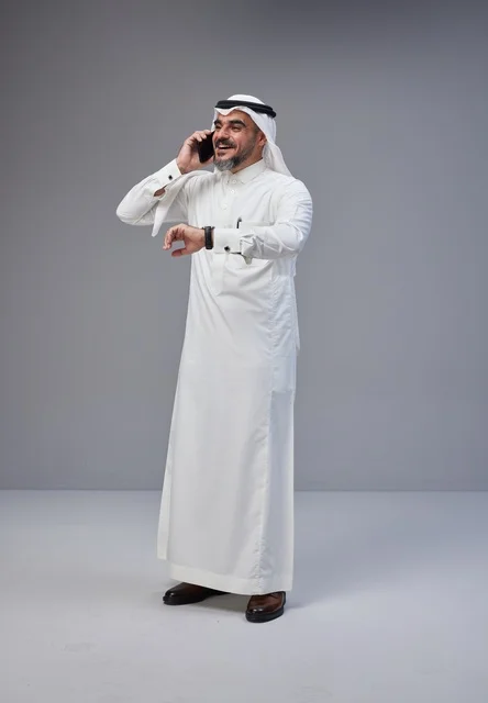 رجل سعودي بالزي التقليدي يتحدث عبر الهاتف الجوال