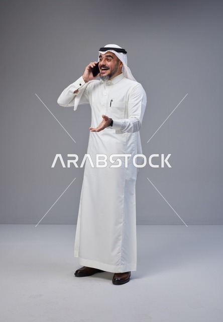 رجل سعودي بالزي التقليدي يتحدث عبر الهاتف المحمول