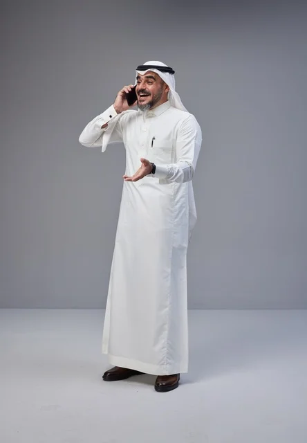 رجل سعودي بالزي التقليدي يتحدث عبر الهاتف المحمول