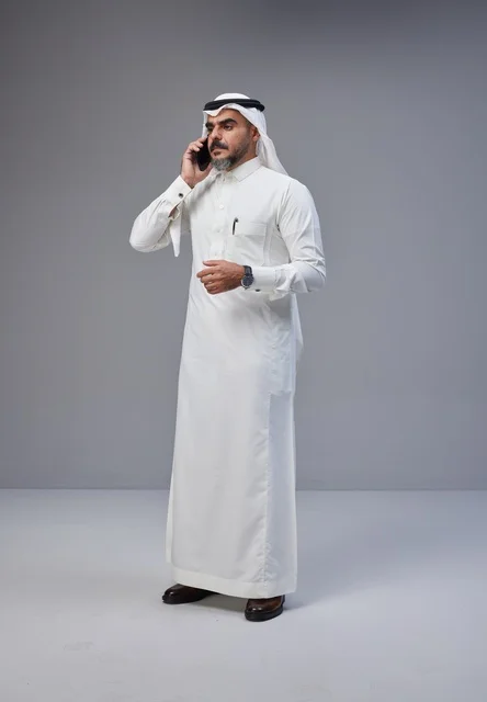 رجل سعودي بالزي التقليدي يتحدث عبر الجوال