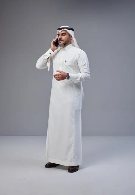 رجل سعودي بالزي التقليدي يتحدث عبر الهاتف الجوال