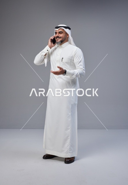 رجل سعودي بالزي التقليدي يتحدث عبر الهاتف