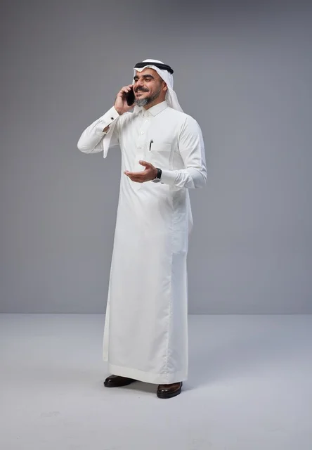 Saudi Man in Traditional Dress Using Mobile Phone