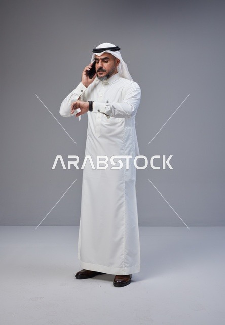 Saudi Man in Traditional Thobe Talking on Phone in Studio