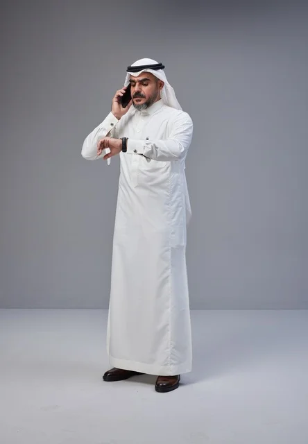 Saudi Man in Traditional Thobe Talking on Phone in Studio