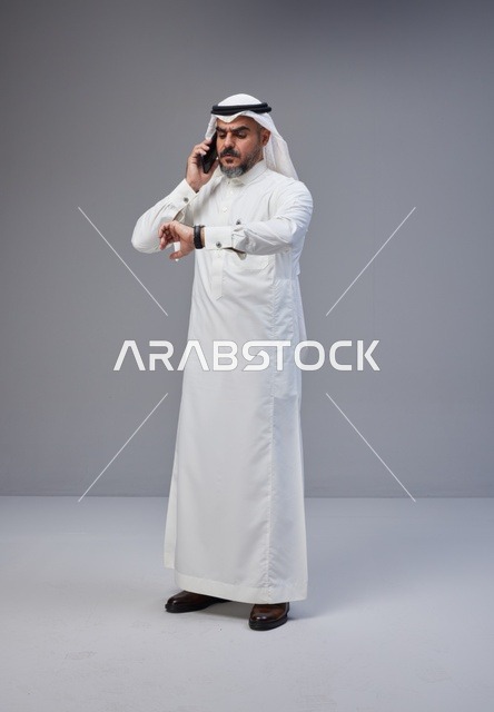 Saudi Man Talking on Phone and Checking Wristwatch