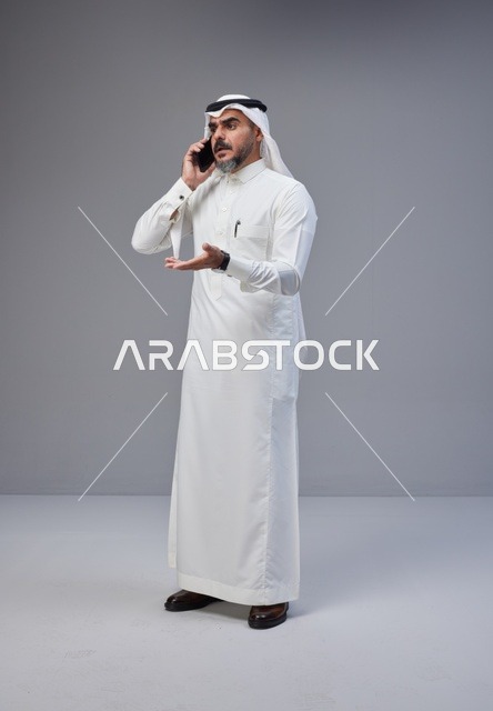 رجل سعودي بالزي التقليدي يتحدث عبر الهاتف