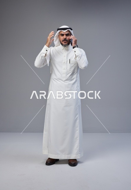 رجل سعودي يتحدث بالهاتف مع إيماءة تعبيرية