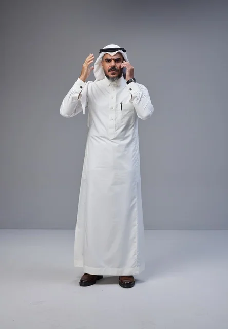 رجل سعودي يتحدث بالهاتف مع إيماءة تعبيرية