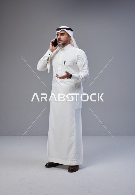 رجل سعودي بالزي التقليدي يتحدث عبر الهاتف