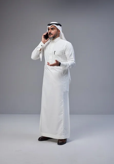 رجل سعودي بالزي التقليدي يتحدث عبر الهاتف