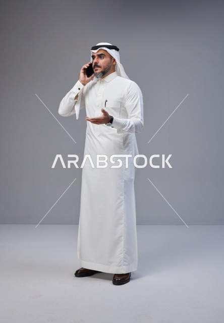 Saudi Man in Traditional Thobe Talking on Mobile Phone