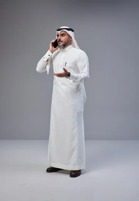 Saudi Man in Traditional Thobe Talking on Mobile Phone