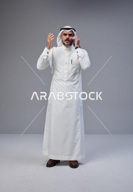 رجل سعودي بالزي التقليدي يتحدث عبر الهاتف