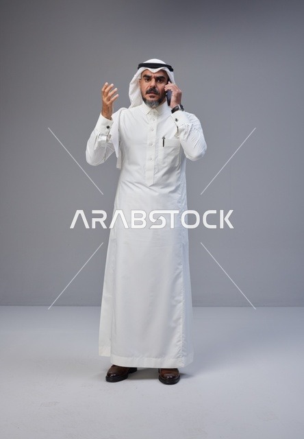 رجل سعودي بالزي التقليدي يتحدث عبر الهاتف
