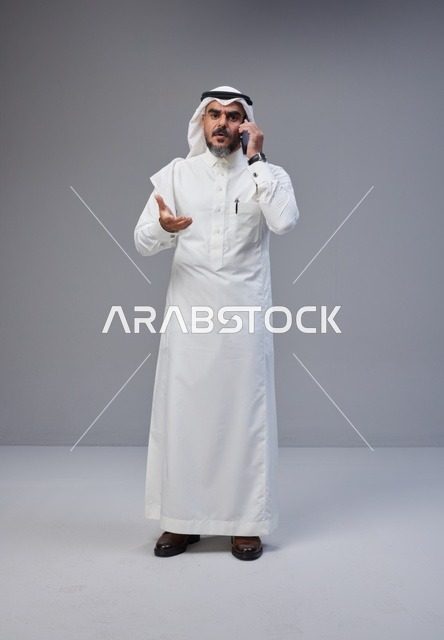 Saudi Man in Traditional Thobe Talking on Phone in Studio