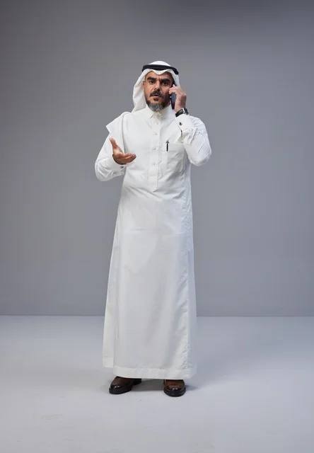 Saudi Man in Traditional Thobe Talking on Phone in Studio