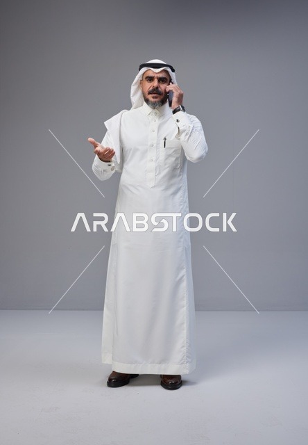 رجل سعودي بالزي التقليدي يتحدث بالهاتف في الاستوديو