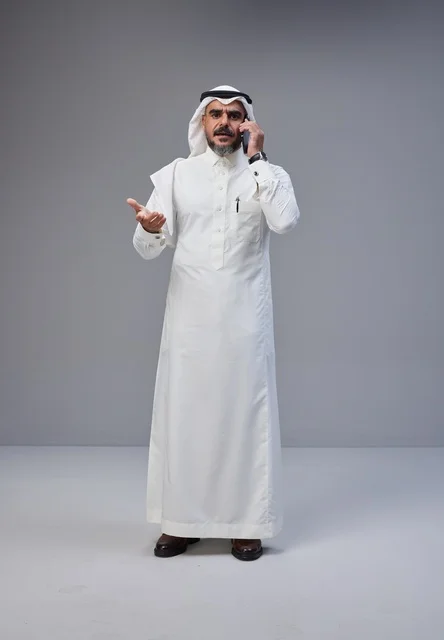 رجل سعودي بالزي التقليدي يتحدث بالهاتف في الاستوديو