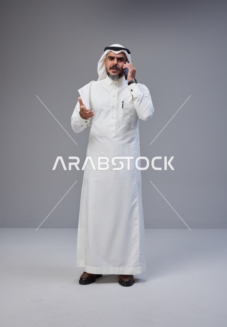 رجل سعودي يتحدث بالهاتف في الاستوديو مع إيماءة
