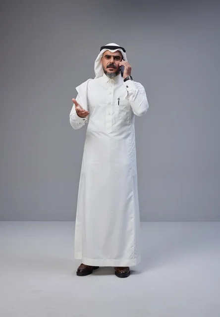 Saudi Man in Traditional Dress Talking on Mobile Phone