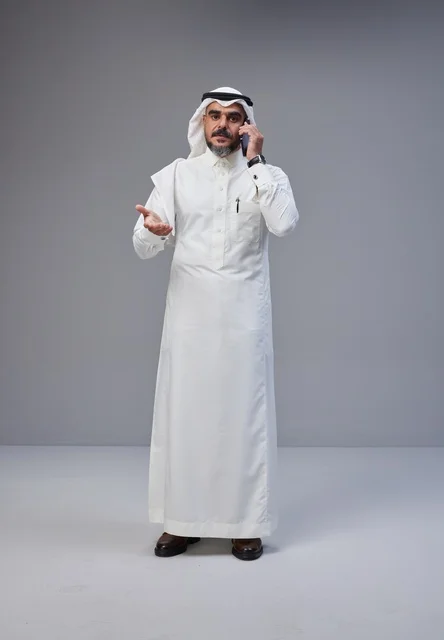 رجل سعودي بالزي التقليدي يتحدث عبر الهاتف الجوال