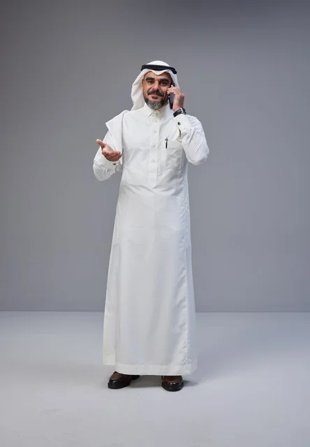Saudi Man in Traditional Thobe Using Mobile Phone