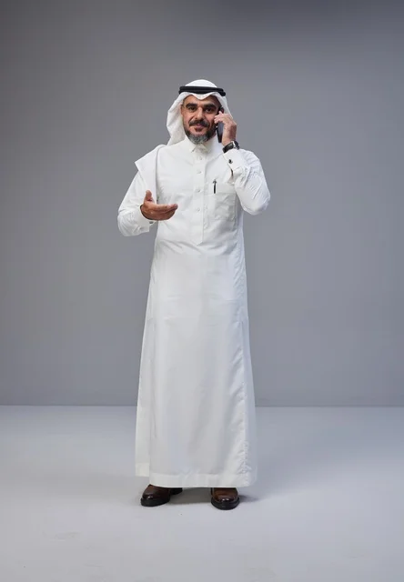 Saudi Man in Traditional Dress Talking on Smartphone