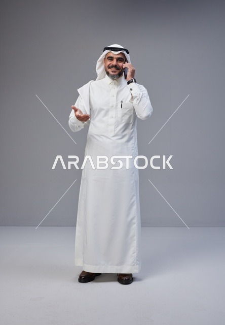 رجل سعودي بالزي التقليدي يتحدث بالجوال