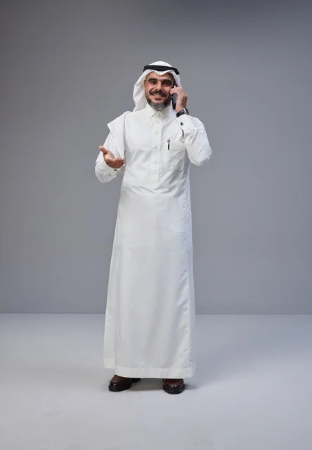 رجل سعودي بالزي التقليدي يتحدث بالجوال